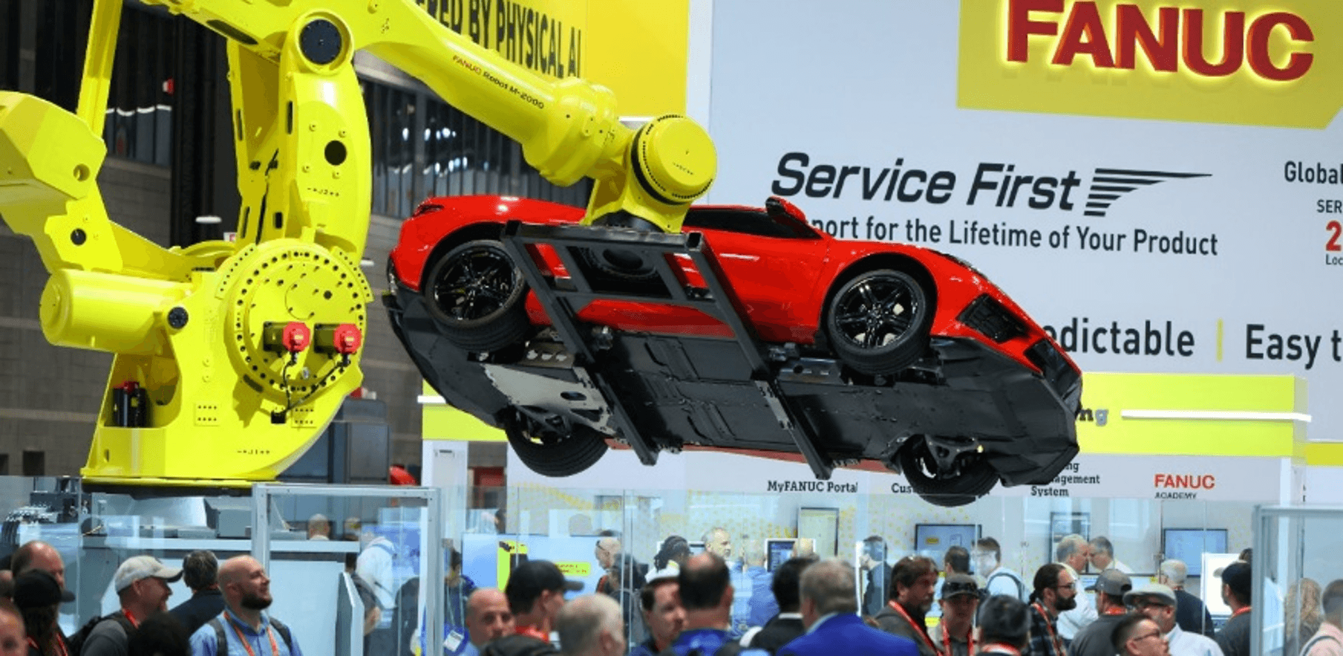 Picture of a FANUC robot arm holding a car at IMTS 2026. Photo courtesy of IMTS.